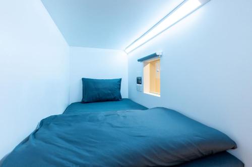 a bed in a small room with a window at Bobopod Mega Mall, Bekasi in Pekayon Satu
