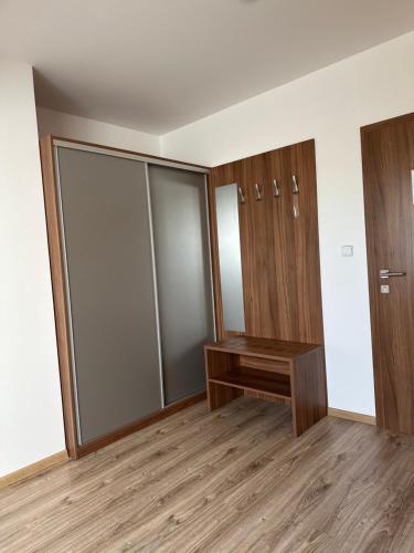 a dressing room with glass doors and a wooden bench at Penzion Blatnička in Blatnička