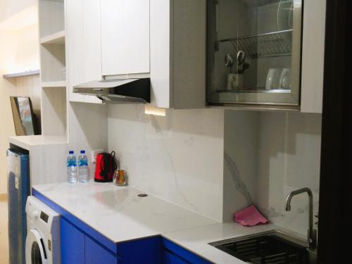 a kitchen with blue cabinets and a white counter top at Meisterstadt Pollux Habibie in Batam Center