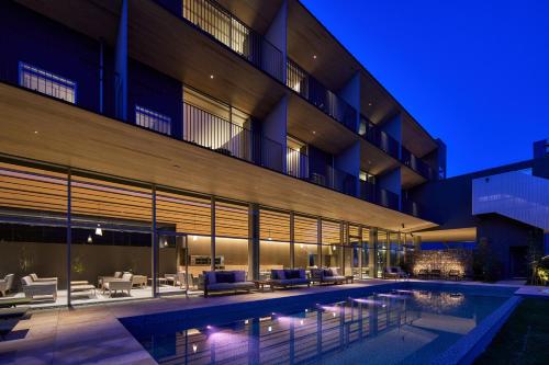 an exterior view of a building with a swimming pool at night at The Meibia Miyazaki in Miyazaki