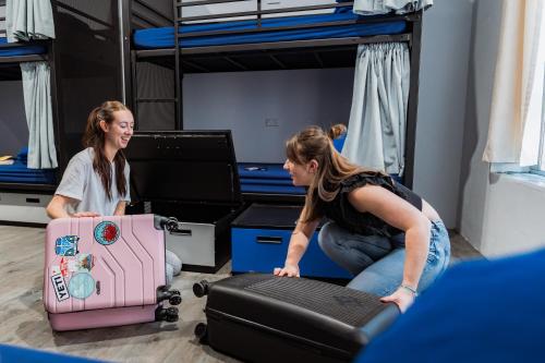 two women sitting on the floor with their luggage at Summer House Sydney City in Sydney