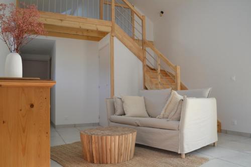 a living room with a couch and a stair case at La métairie du rumain in Troguéry