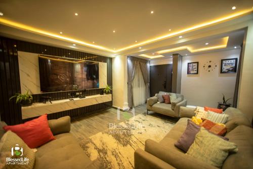 a living room with two couches and a television at Blessedlife Apartment in Kumasi
