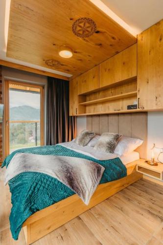a bedroom with a bed in a room with a window at Apartamenty Butorowy in Kościelisko