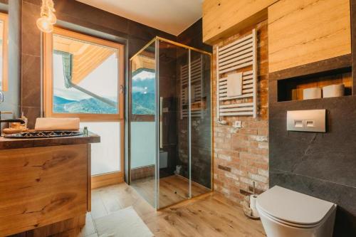 a bathroom with a glass shower and a toilet at Apartamenty Butorowy in Kościelisko