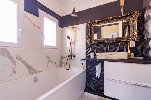 La salle de bains est pourvue d'un miroir et d'une baignoire. dans l'établissement Ohm Sweet Home - Maison climatisée, à Carcassonne
