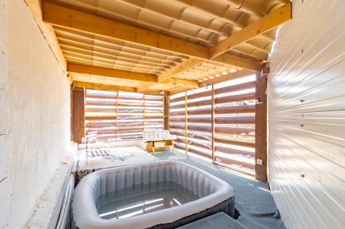 Cette chambre dispose de murs en bois et d'une grande baignoire. dans l'établissement Ohm Sweet Home - Maison climatisée, à Carcassonne