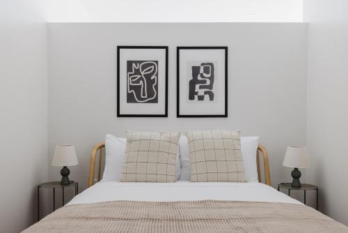 a bedroom with two framed pictures above a bed at Blueground Revere spa gym pool wd lounge BOS-1100 in Boston