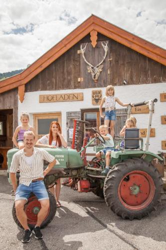 a group of children sitting on a tractor in front of a building at Beim Heiß'n in Staudach-Egerndach