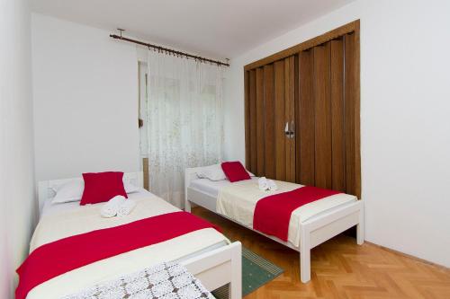 1 dormitorio con 2 camas con sábanas rojas y blancas en Sunny Apartment, en Omiš