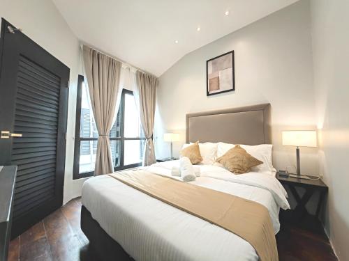 a bedroom with a large bed and two windows at Cozy Home 3BR 8pax The Prive Malacca Jonker Street in Melaka