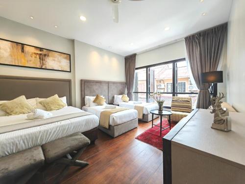 a hotel room with two beds and a couch at Cozy Home 3BR 8pax The Prive Malacca Jonker Street in Melaka