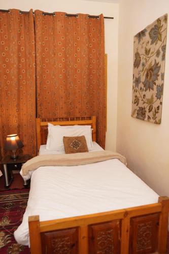 a bedroom with a bed with a wooden headboard at Duroyo hotel in Gilgit