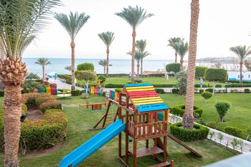 a playground with palm trees and the ocean in the background at Grand Oasis Resort in Sharm El Sheikh