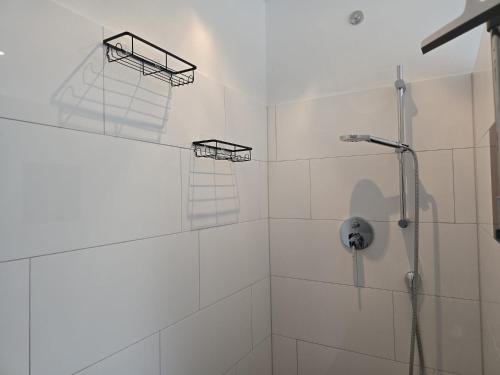 a white bathroom with a shower with a shower head at Ferienwohnung Morgensonne Mölln in Mölln