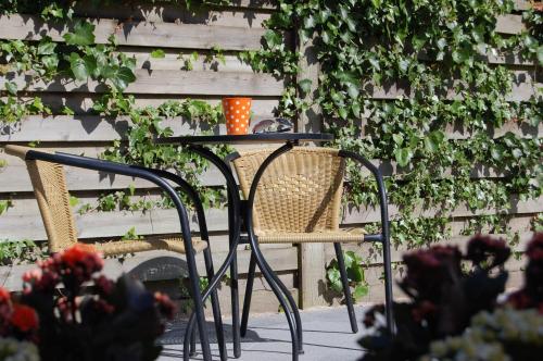 a table and chairs sitting next to a fence at Den Gamle Købmandsgaard Bed & Breakfast in Ribe