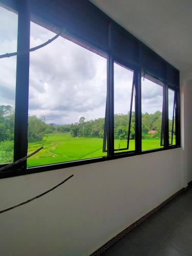 a window with a view of a green field at Wisma Samrat in Rantepao