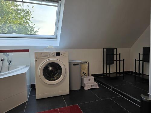 a laundry room with a washing machine and a window at Ferienwohnung Morgensonne Mölln in Mölln