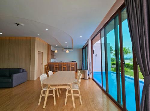a dining room and living room with a table and chairs at Sunrise Resort & Cafe - ซันไรส์ รีสอร์ท & คาเฟ่ in Nakhon Phanom