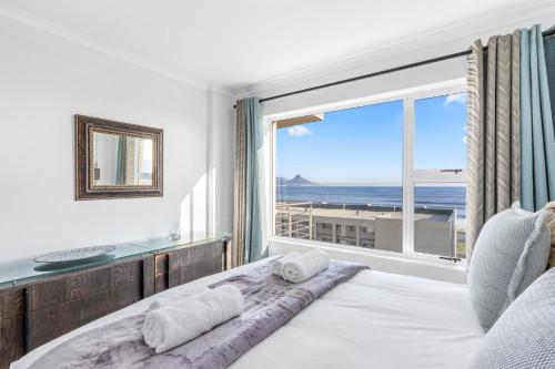 a bedroom with a large window with a view of the ocean at The Waves 302 in Bloubergstrand