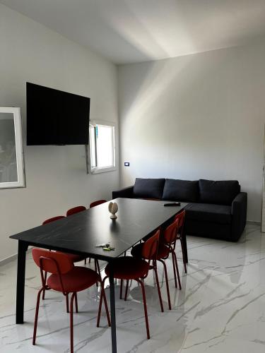 a living room with a black table and chairs at Pool Seaside Relais - VILLE Ninfea, Marea, Rosa e Cassiopea in Fontane Bianche