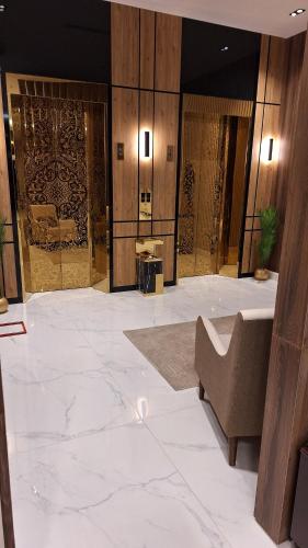 a lobby with white marble floors and a couch at دار الرياض للشقق المخدومة بالخبر 2 in Al Khobar