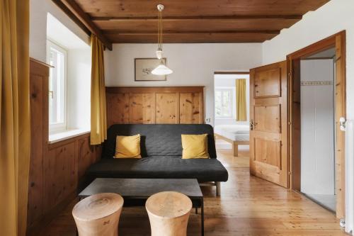 a living room with a black couch and yellow pillows at Sonnhof in Bad Ischl