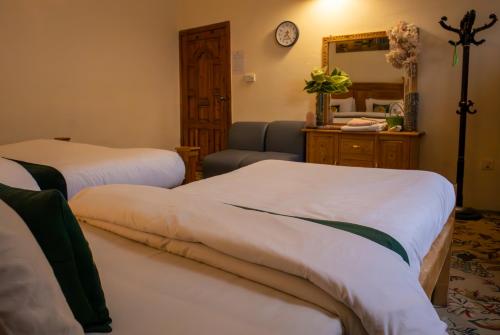 a hotel room with two beds and a mirror at Duroyo hotel in Gilgit