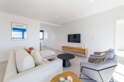 a living room with two couches and a tv at Oceans Oliva in Oliva