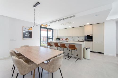 a kitchen and dining room with a wooden table and chairs at Oceans Oliva in Oliva