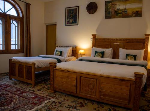 a bedroom with two beds and a window at Duroyo hotel in Gilgit