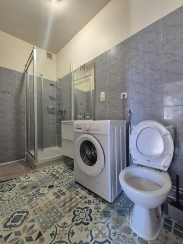 une salle de bain avec machine à laver et toilettes dans l'établissement #L'Instant#Terrasse #Thiers#, à Thiers