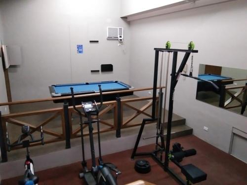 a room with a gym with a table and weights at Royale Parc Hotel Tagaytay in Tagaytay