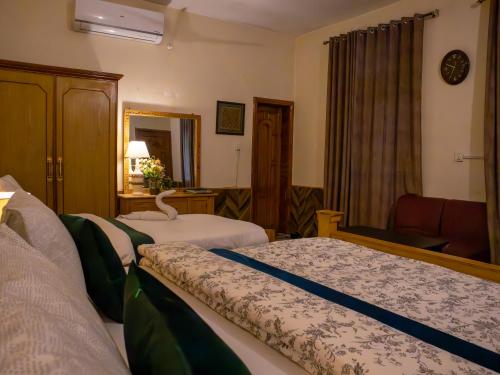 a hotel room with two beds and a chair at Duroyo hotel in Gilgit