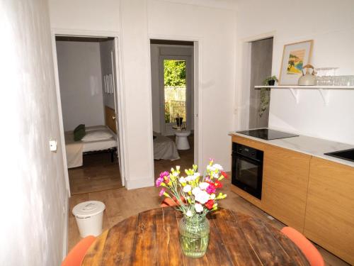 une cuisine avec une table en bois et des fleurs. dans l'établissement La maison by Simone T3, à Cannes