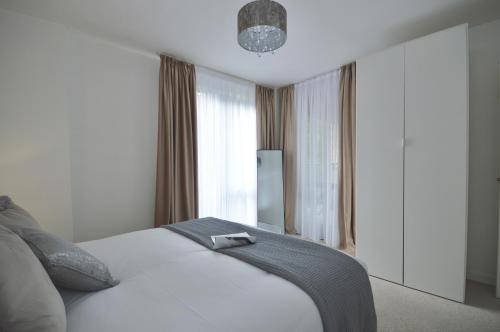 a bedroom with a white bed and a large window at Modern 2 Bedroom Apartment Steps from Vauxhall St in London