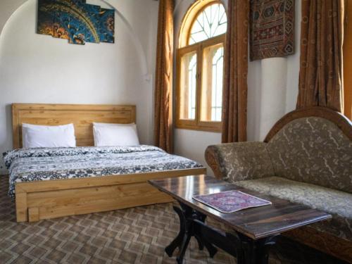 a bedroom with a bed and a couch and a table at Duroyo hotel in Gilgit