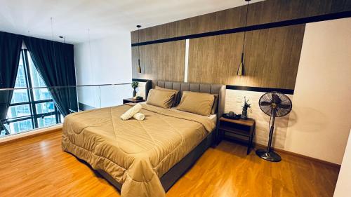 a bedroom with a large bed and a fan at EkoCheras Suites, Kuala Lumpur by Idealhomes in Kuala Lumpur