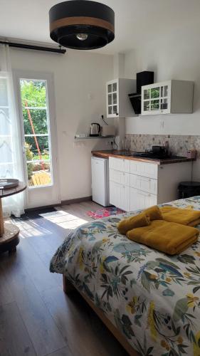 a bedroom with a large bed and a kitchen at Une pause à la campagne Classé 2 étoiles in Saint-Urbain