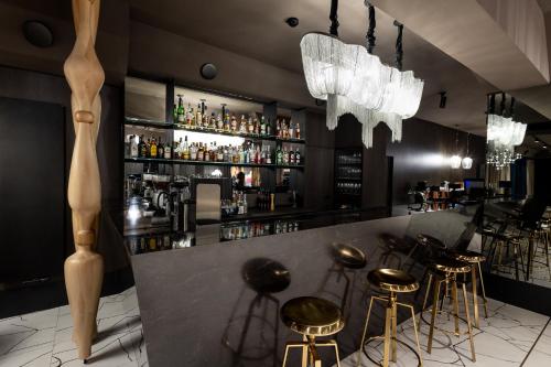 a bar with gold stools and a counter with alcohol at Hotel 3 Trio in Białystok