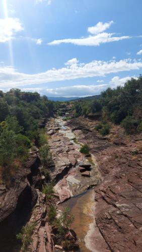 a river on the side of a rocky mountain at Escale au Salagou in Le Bosc