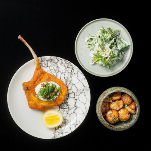 a plate of food with a fish and a bowl of salad at Hotel 3 Trio in Białystok