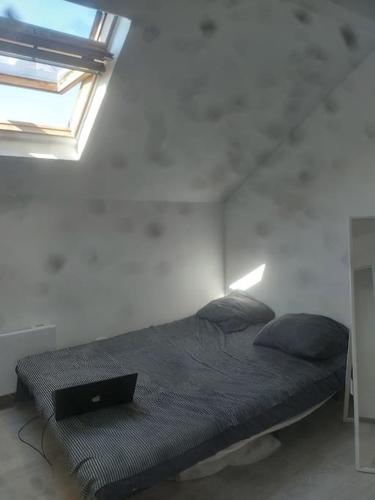 une chambre avec un lit avec un ordinateur portable dessus dans l'établissement Petit Simple Studio In Paris Romainville Carnot, à Romainville