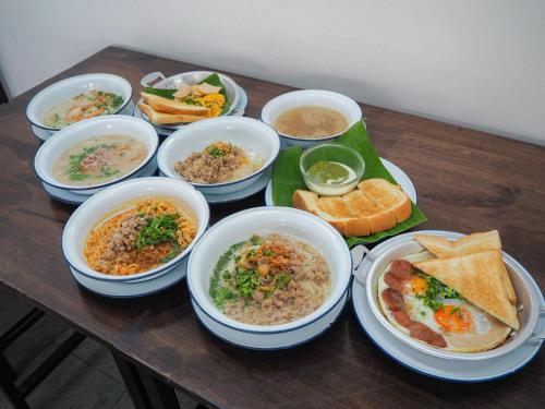 einen Holztisch mit Schalen mit Essen und Brot in der Unterkunft Blu Monkey Bed & Breakfast Phuket in Phuket