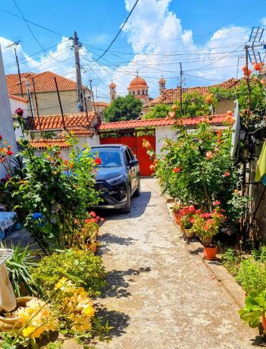 a car parked in front of a yard with flowers at Liora's Place in Korçë