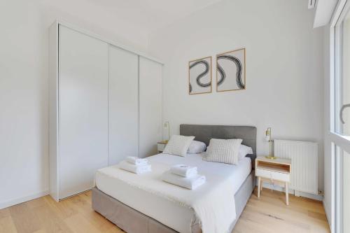 une chambre blanche avec un lit et une table dans l'établissement Modern Apartment - 1BD-4P - PMR - Nogent-sur-Marne, à Nogent-sur-Marne
