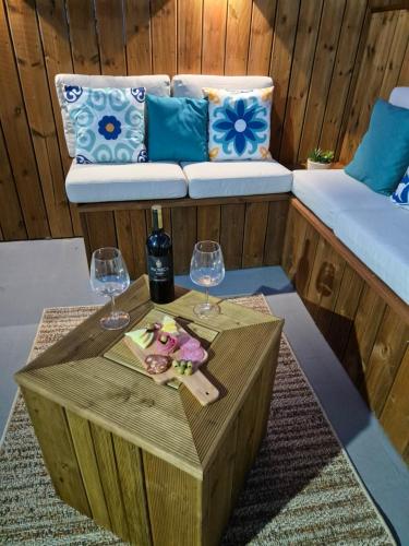 a coffee table with two wine glasses and a couch at Pêra Holiday House in Pêra
