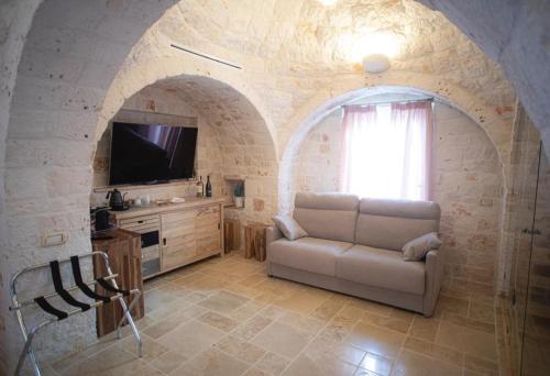 a living room with a couch and a tv at La Terrazza Sulla Rupe Relais in Ostuni