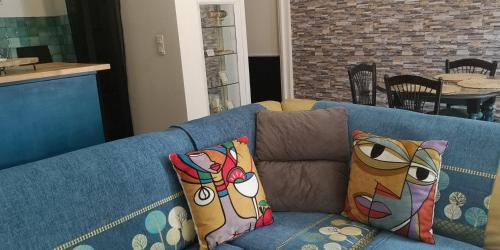 a blue couch with pillows in a living room at L'Empire D'Essences Appartement in Valréas