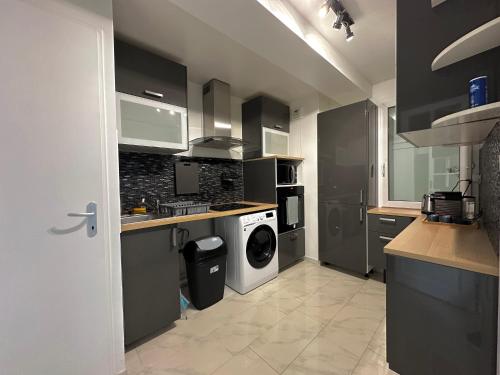 Il comprend une cuisine équipée d'un lave-linge et d'un sèche-linge. dans l'établissement Appartement Confort à Louvres proche CDG, à Louvres